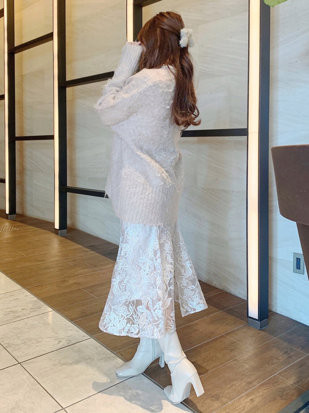 ベージュ系のスカート、ブラウン系のカーディガン/ボレロ、ホワイト系のブーツを着用したレディースの冬コーディネートの6枚目の写真