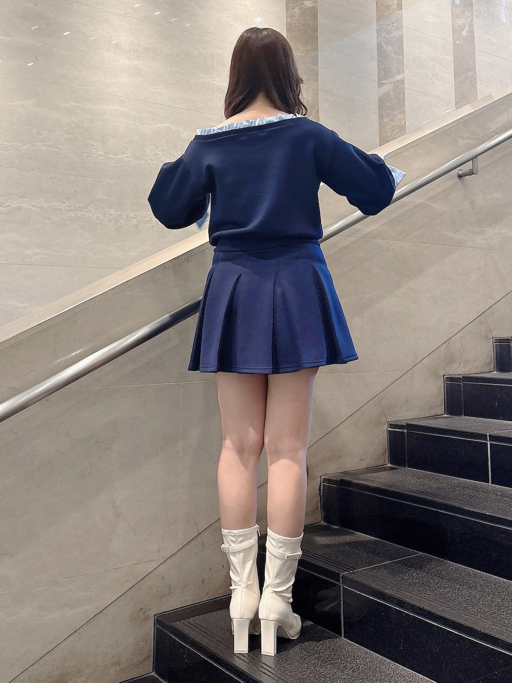 ブルー系のTシャツ/カットソー、ブルー系のスカート、ホワイト系のブーツを着用したレディースの春コーディネートの4枚目の写真