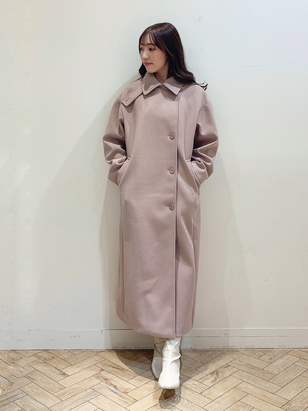 ブルー系のワンピース、ホワイト系のブーツ、ベージュ系のステンカラーコートを着用したレディースの冬コーディネートの8枚目の写真