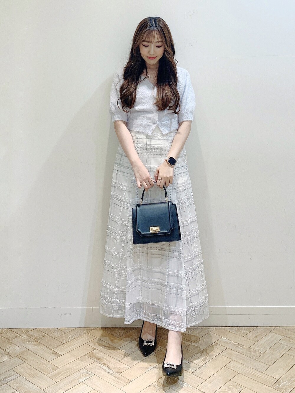 パープル系のカーディガン/ボレロ、ブラック系のスカート、ブラック系のパンプスを着用したレディースの夏コーディネートの2枚目の写真