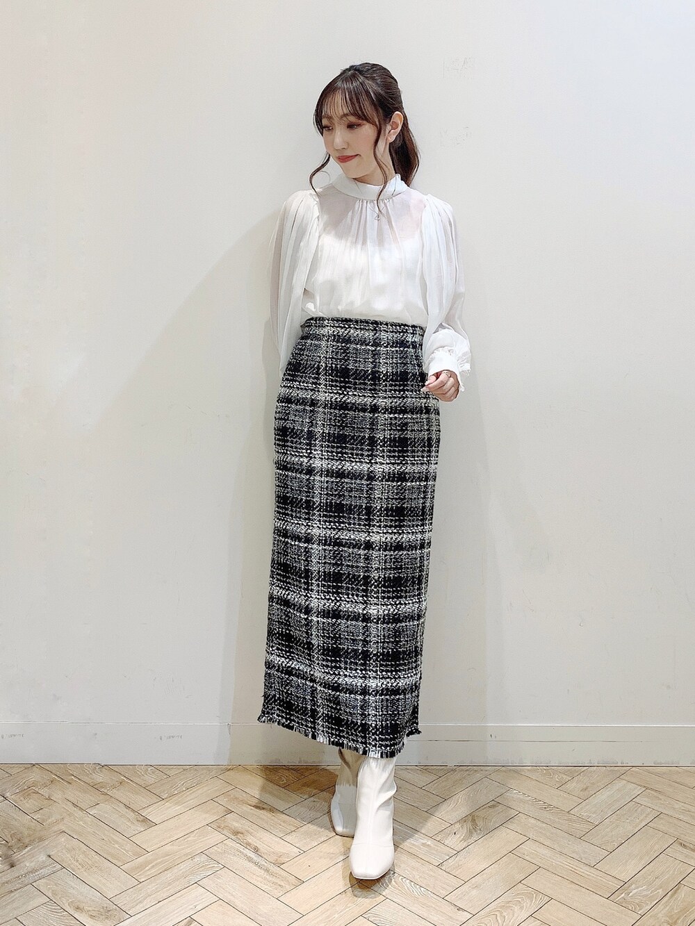 ブラック系のダウンジャケット/コート、ホワイト系のシャツ/ブラウス、ブラック系のスカートを着用したレディースの冬コーディネートの3枚目の写真