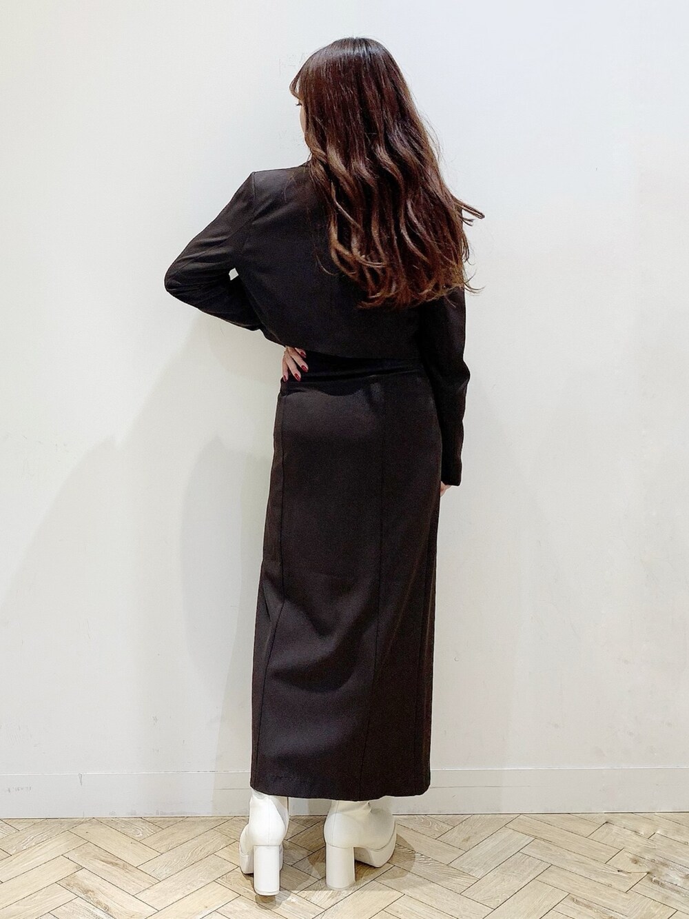 ブラウン系のスカート、ホワイト系のブーツ、ホワイト系のシャツ/ブラウスを着用したレディースの秋コーディネートの5枚目の写真