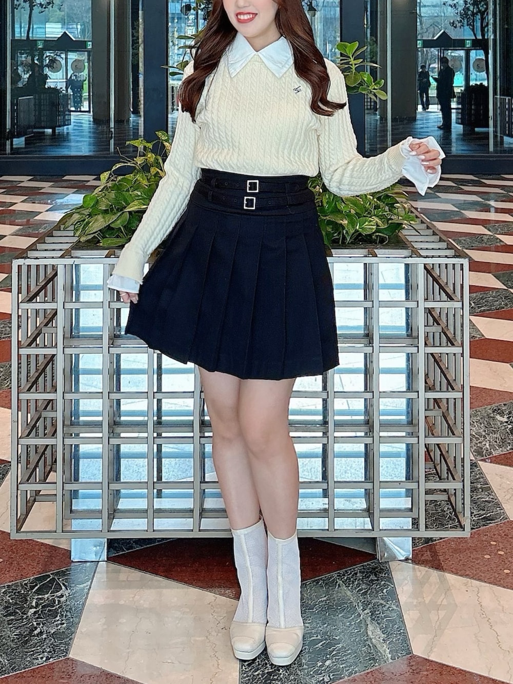 ホワイト系のブーツ、ブラック系のスカート、ホワイト系のニット/セーターを着用したレディースの冬コーディネートの5枚目の写真