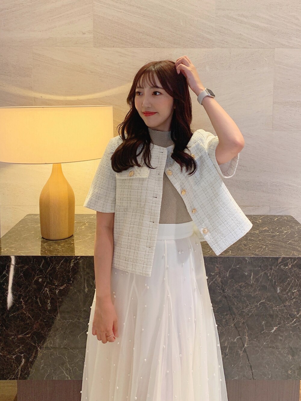 ホワイト系のスカート、ホワイト系のノーカラージャケット、ベージュ系のニット/セーターを着用したレディースの夏コーディネートの8枚目の写真