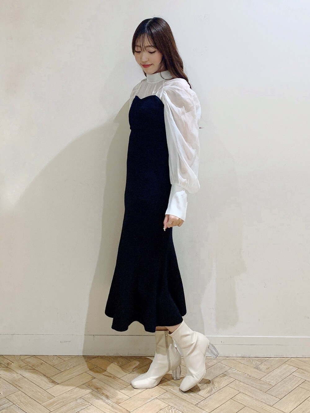 ブラック系のワンピース、ホワイト系のブーツを着用したレディースの冬コーディネートの5枚目の写真