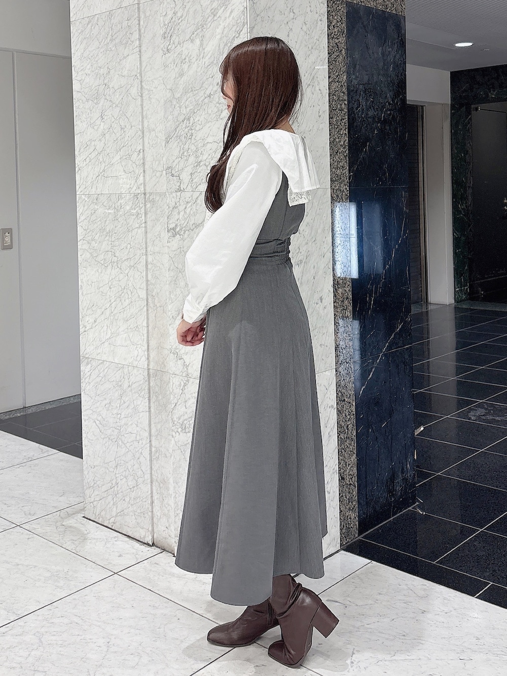 グレー系のワンピース、ブラウン系のブーツを着用したレディースの冬コーディネートの3枚目の写真