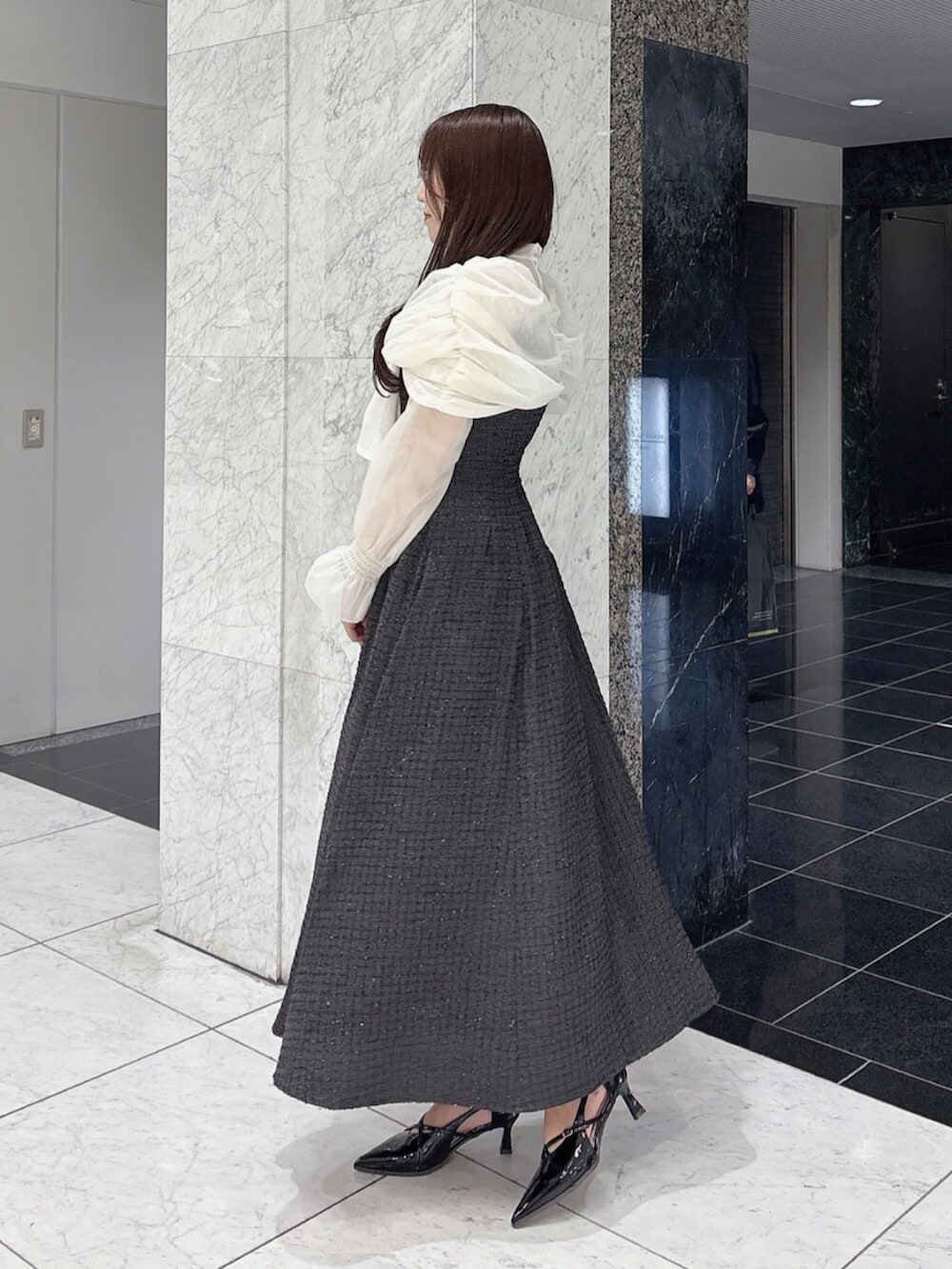 ブラック系のパンプス、ブラック系のドレスを着用したレディースの冬コーディネートの2枚目の写真