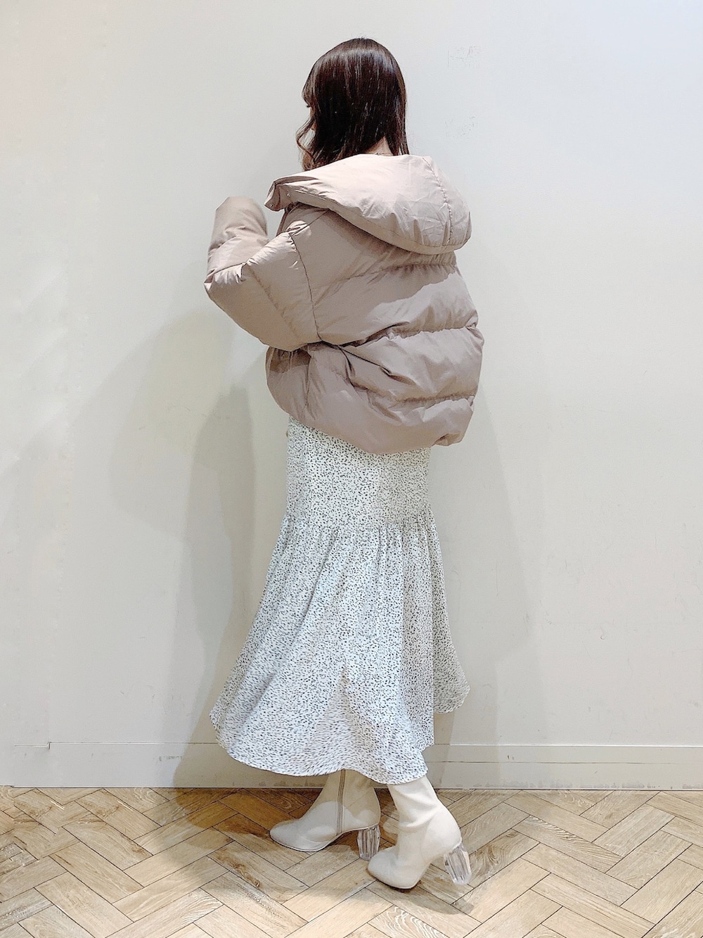 ホワイト系のワンピース、ブラウン系のダウンジャケット/コート、ホワイト系のブーツを着用したレディースの冬コーディネートの7枚目の写真