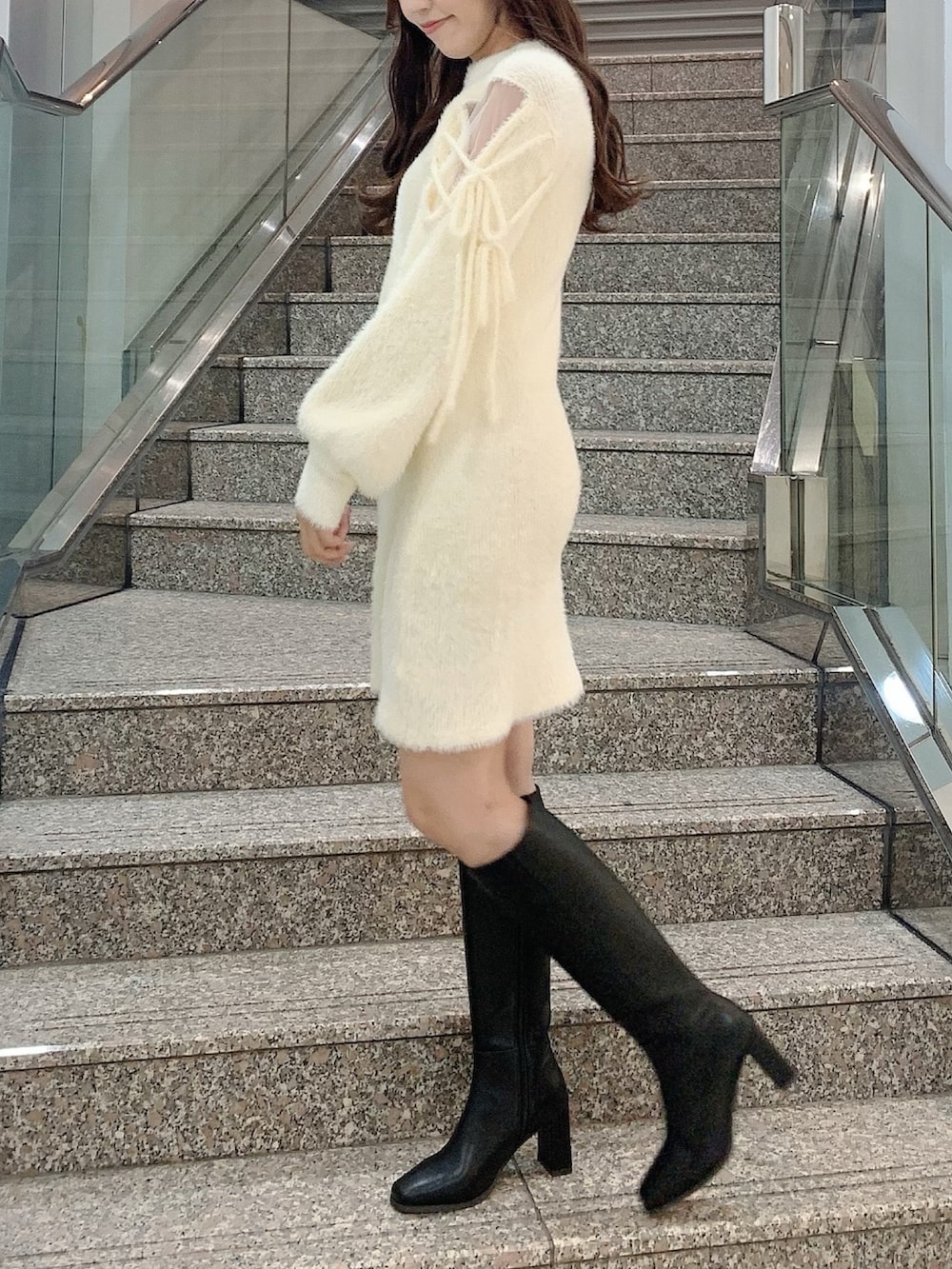 ブラック系のブーツ、ホワイト系のワンピースを着用したレディースの冬コーディネートの4枚目の写真