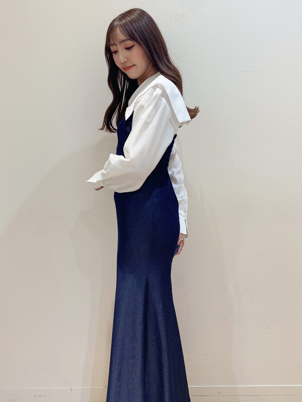 ブルー系のワンピース、ホワイト系のブーツ、ベージュ系のステンカラーコートを着用したレディースの冬コーディネートの10枚目の写真