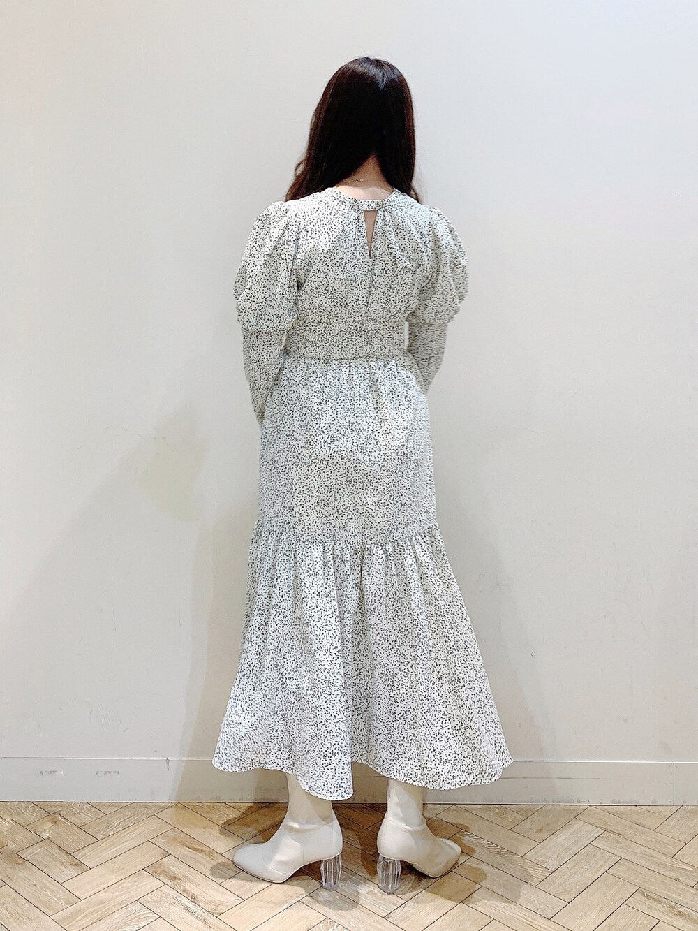 ホワイト系のワンピース、ブラウン系のダウンジャケット/コート、ホワイト系のブーツを着用したレディースの冬コーディネートの5枚目の写真