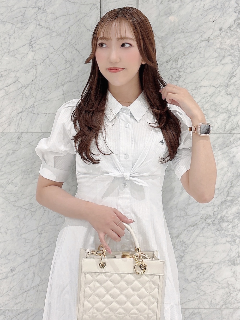 ホワイト系のワンピース、ホワイト系のパンプス、ホワイト系のハンドバッグを着用したレディースの春コーディネートの9枚目の写真