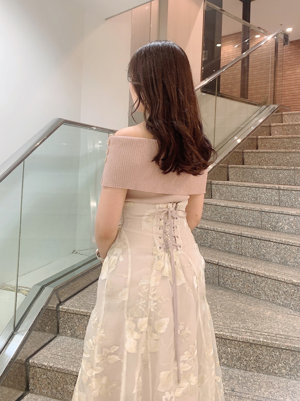 ベージュ系のスカート、ピンク系のニット/セーター、シルバー系のパンプスを着用したレディースの夏コーディネートの7枚目の写真