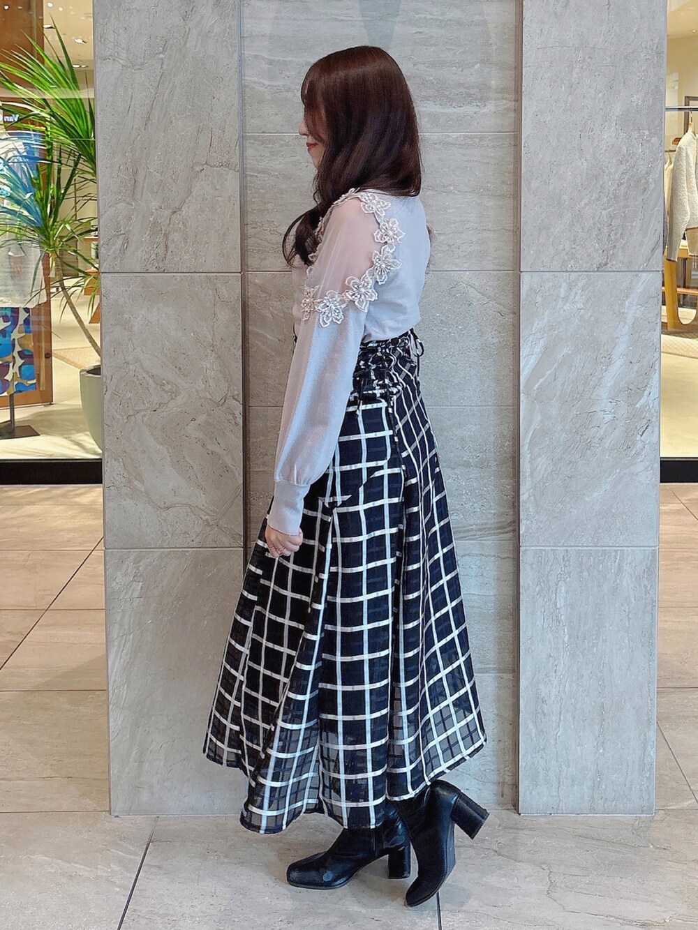 ブラック系のブーツ、ブラック系のスカート、ピンク系のニット/セーターを着用したレディースの冬コーディネートの3枚目の写真