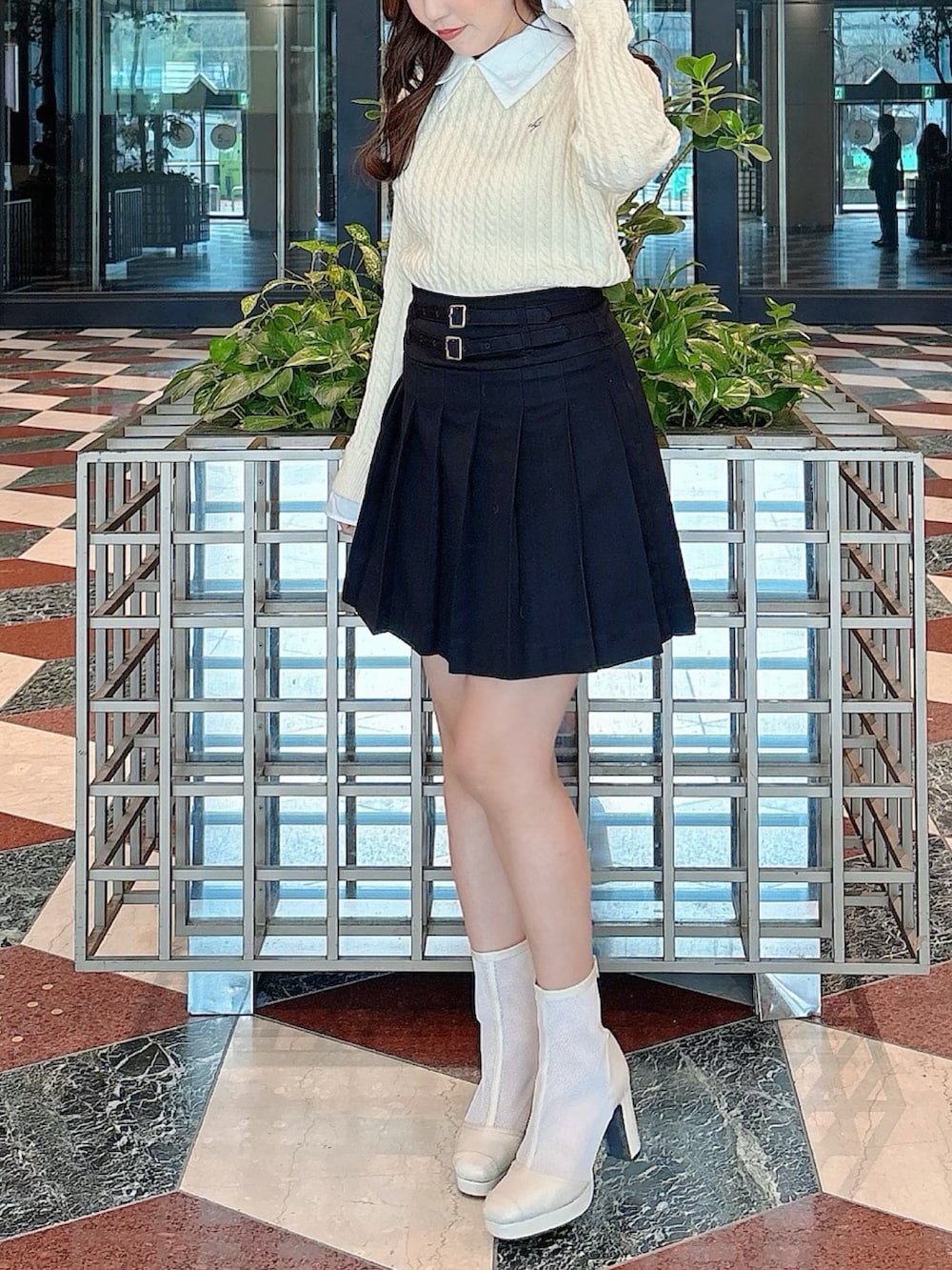 ホワイト系のブーツ、ブラック系のスカート、ホワイト系のニット/セーターを着用したレディースの冬コーディネートの4枚目の写真