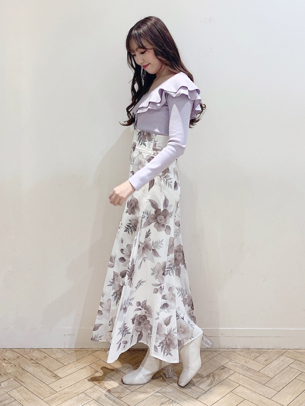 パープル系のニット/セーター、ホワイト系のスカート、ホワイト系のブーツを着用したレディースの冬コーディネートの4枚目の写真