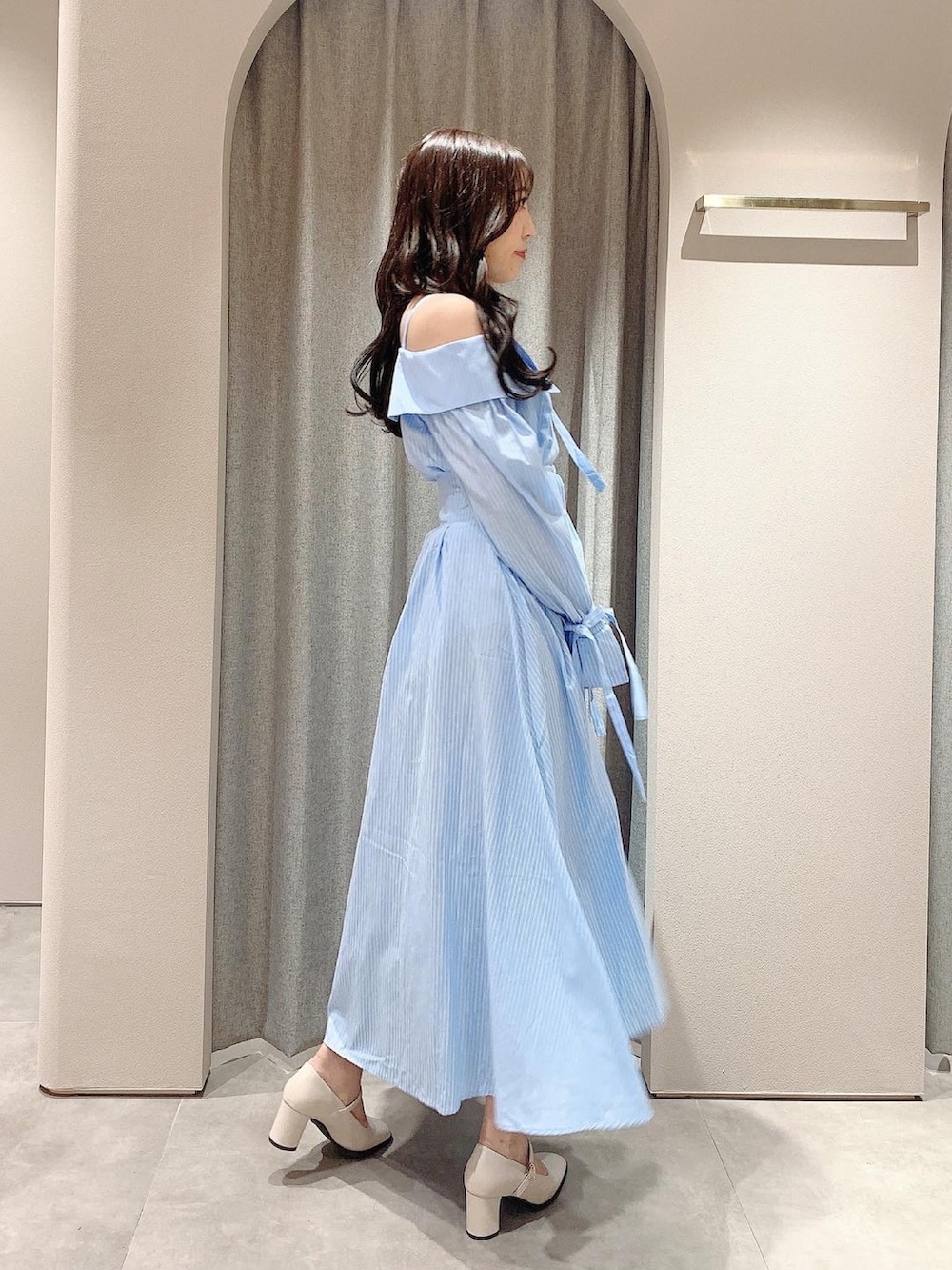 ブルー系のシャツワンピース、ホワイト系のテーラードジャケット、ホワイト系のパンプスを着用したレディースの冬コーディネートの4枚目の写真