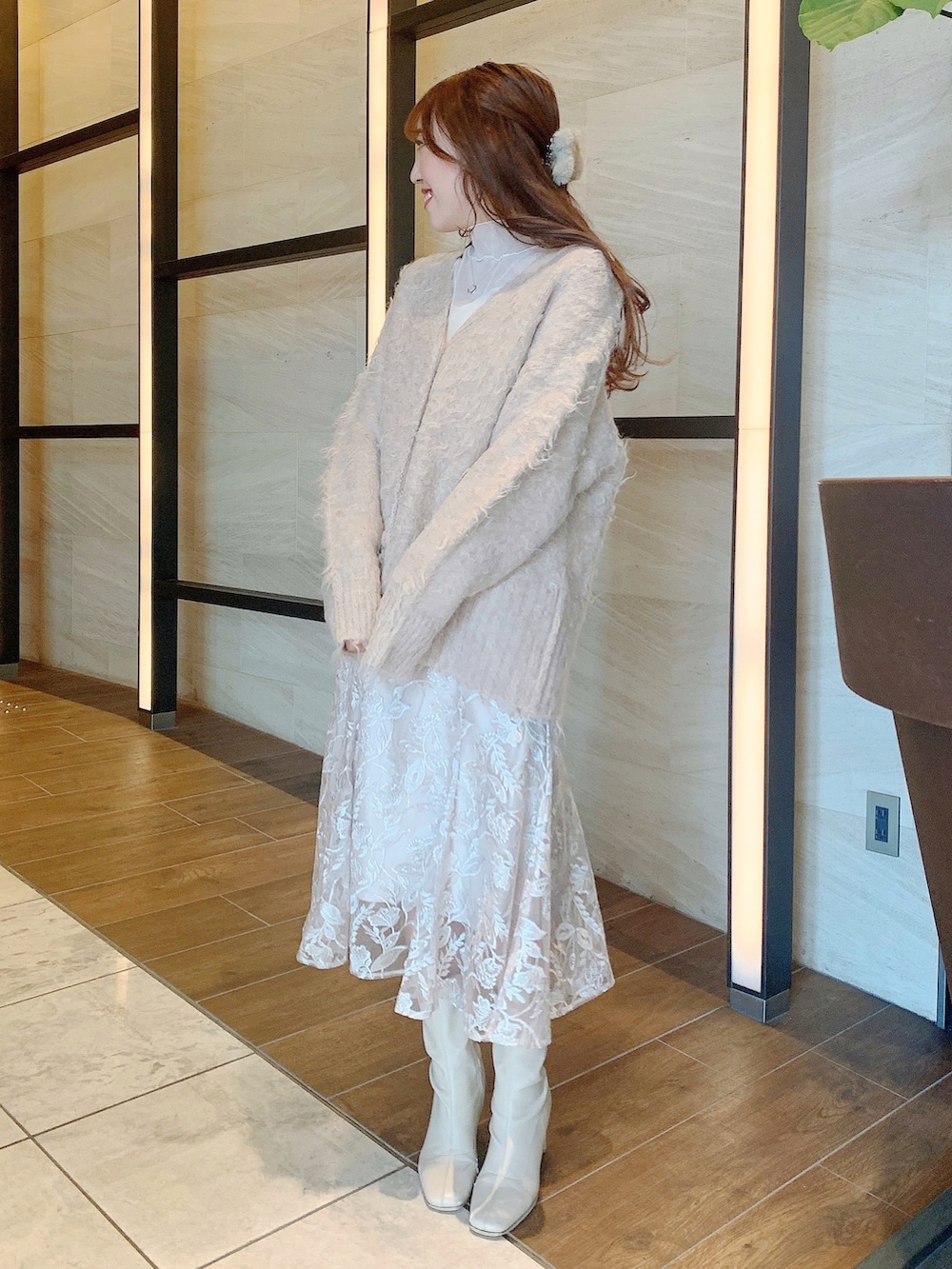 ベージュ系のスカート、ブラウン系のカーディガン/ボレロ、ホワイト系のブーツを着用したレディースの冬コーディネートの4枚目の写真