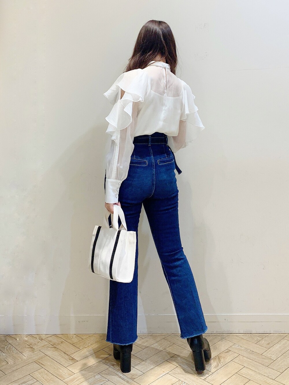 ホワイト系のシャツ/ブラウス、ブルー系のデニムパンツ、ホワイト系のハンドバッグを着用したレディースの冬コーディネートの6枚目の写真