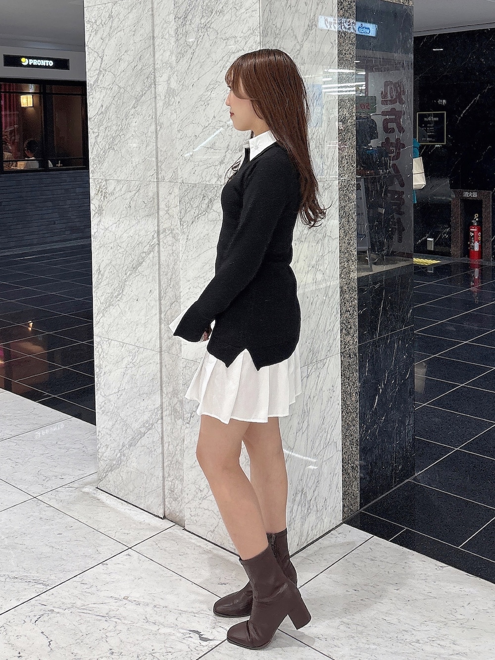 ブラック系のワンピース、ブラウン系のブーツを着用したレディースの秋コーディネートの4枚目の写真