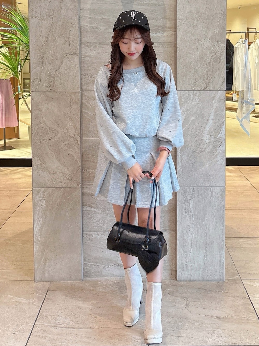 ホワイト系のブーツ、グレー系のスカート、グレー系のスウェットを着用したレディースの春コーディネートの3枚目の写真
