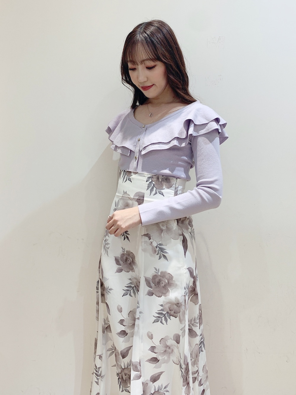 パープル系のニット/セーター、ホワイト系のスカート、ホワイト系のブーツを着用したレディースの冬コーディネートの6枚目の写真