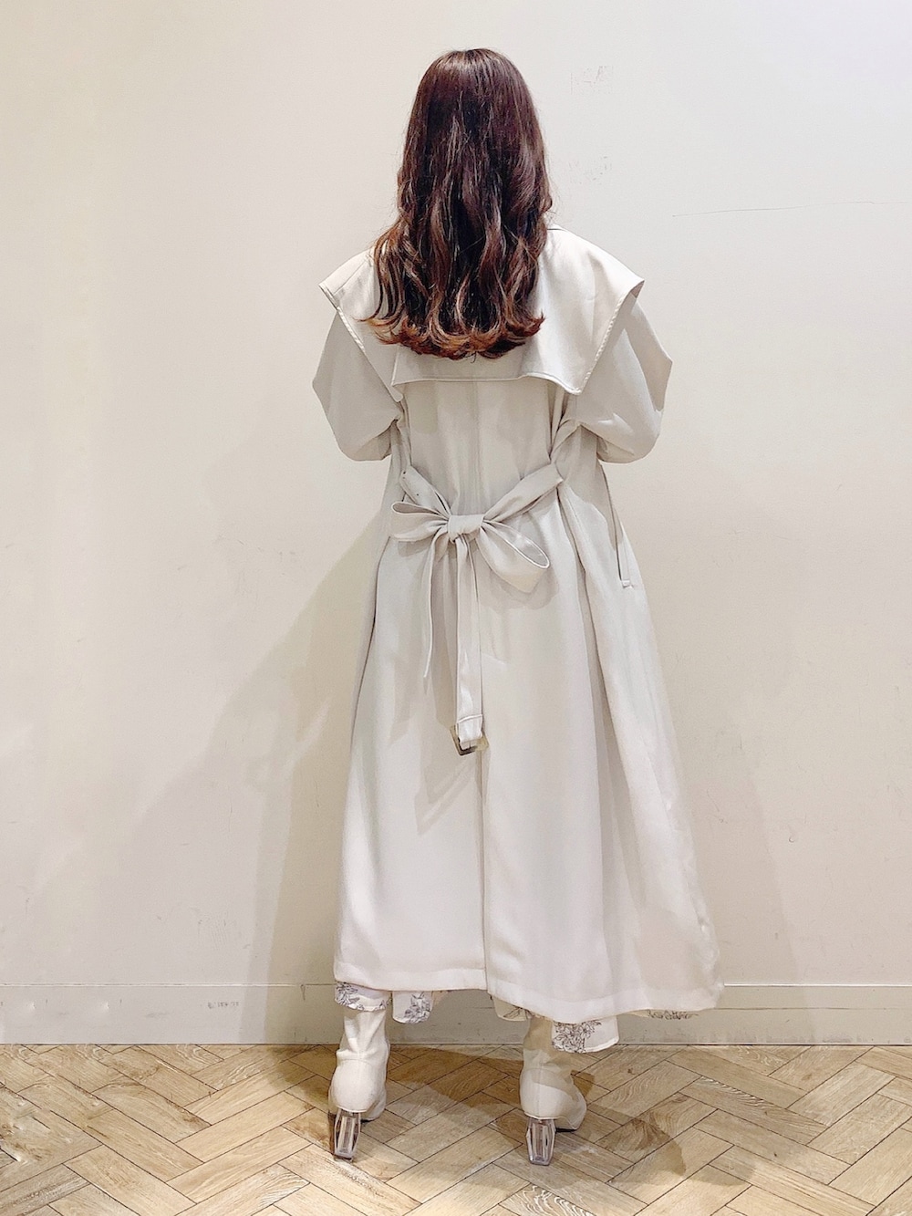 ホワイト系のワンピース、ホワイト系のトレンチコートを着用したレディースの冬コーディネートの7枚目の写真