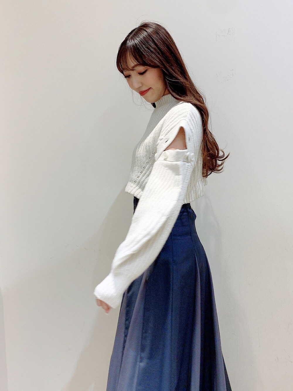 グレー系のスカート、ホワイト系のワンピース、ブラウン系のブーツを着用したレディースの冬コーディネートの8枚目の写真