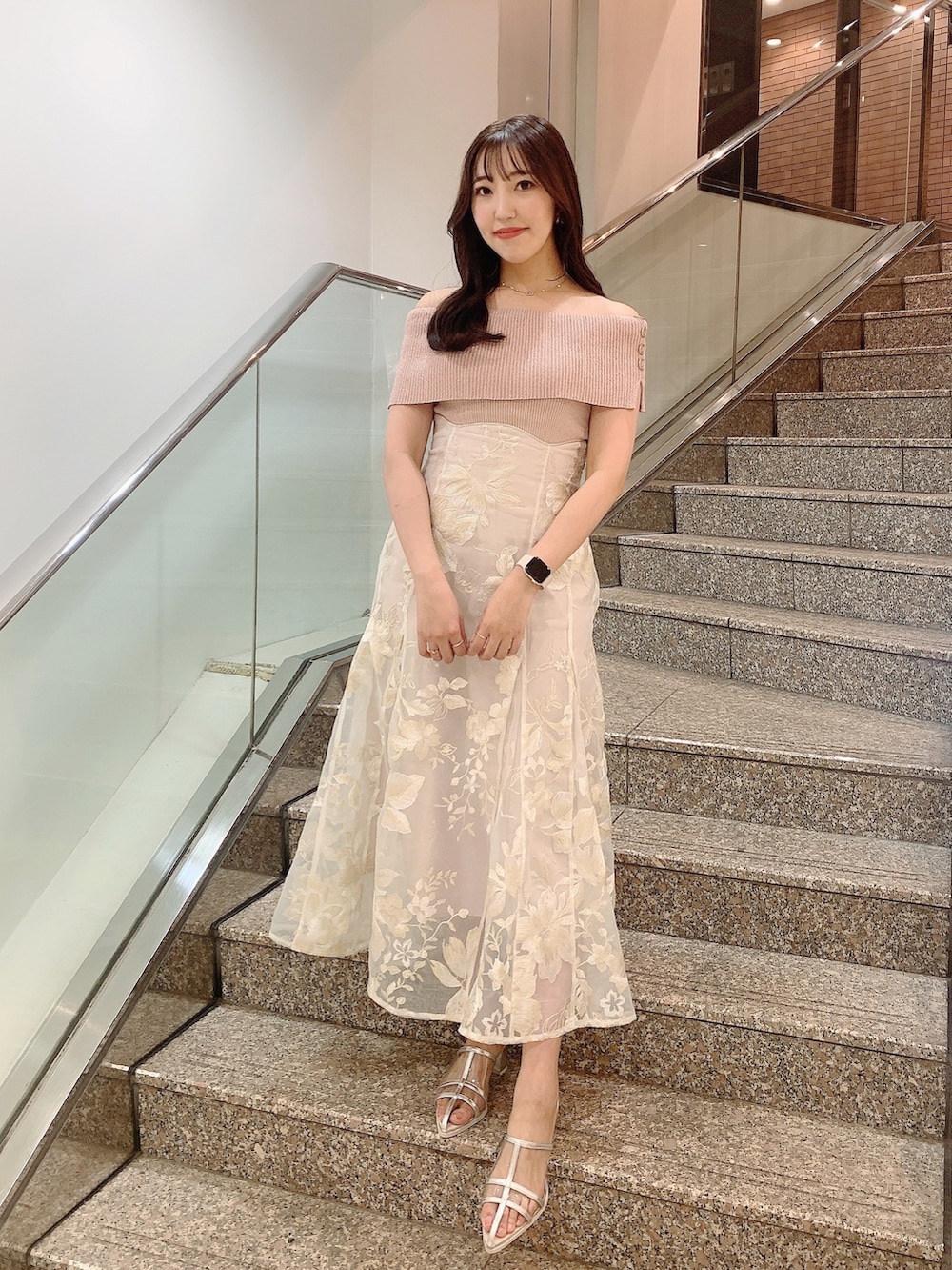 ベージュ系のスカート、ピンク系のニット/セーター、シルバー系のパンプスを着用したレディースの夏コーディネートの2枚目の写真