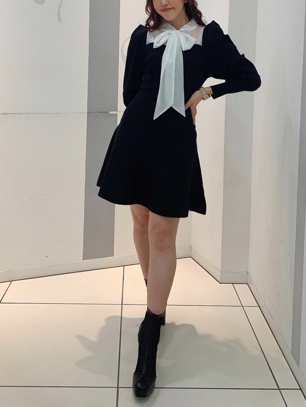 ブラック系のワンピース、ブラック系のブーツを着用したレディースの冬コーディネートの2枚目の写真