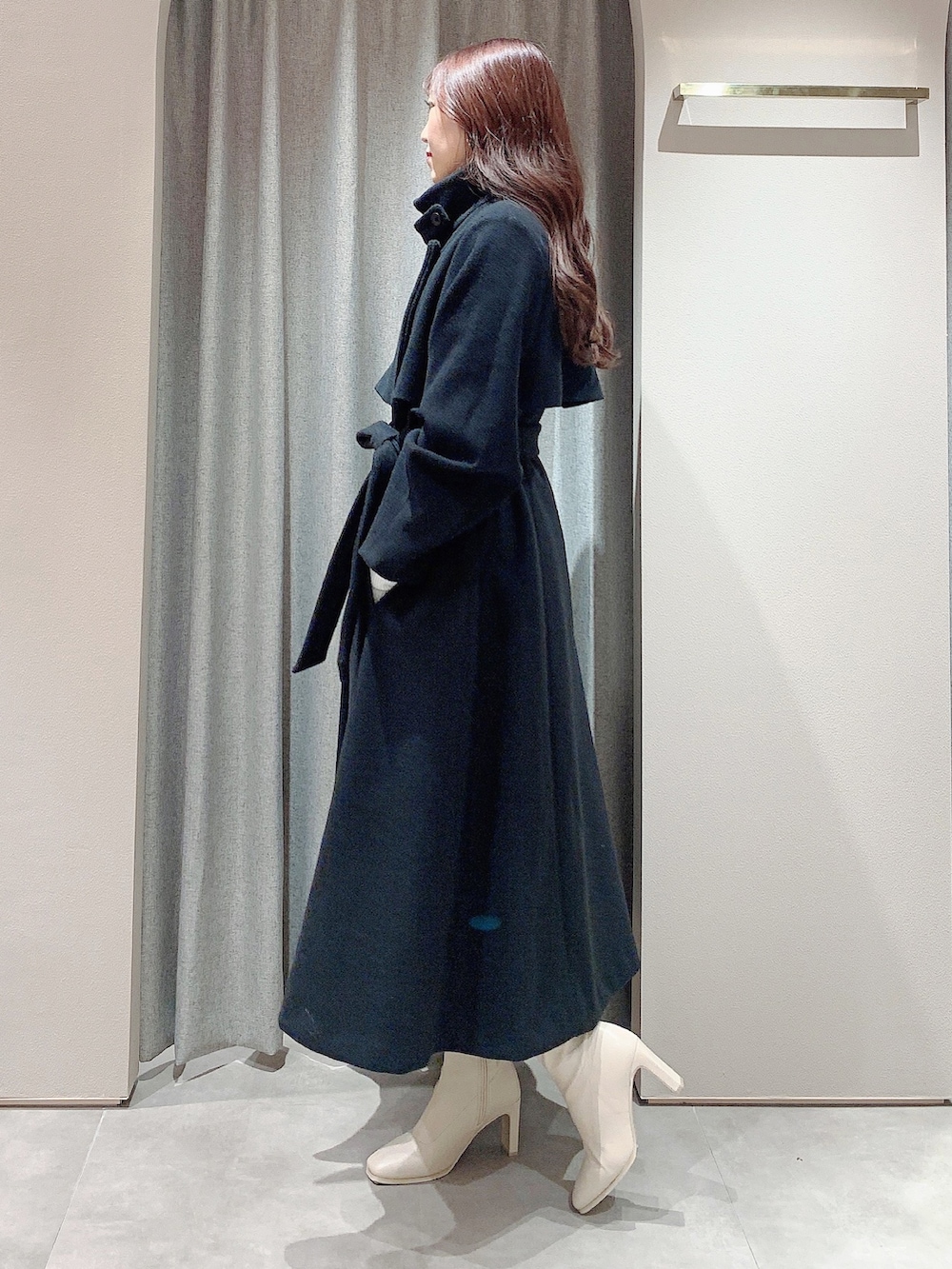 ホワイト系のワンピース、ホワイト系のブーツ、ブラック系のその他アウターを着用したレディースの冬コーディネートの6枚目の写真