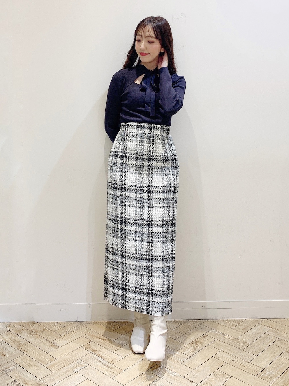 ホワイト系のスカート、ブラウン系のニット/セーター、ホワイト系のブーツを着用したレディースの秋コーディネートの2枚目の写真