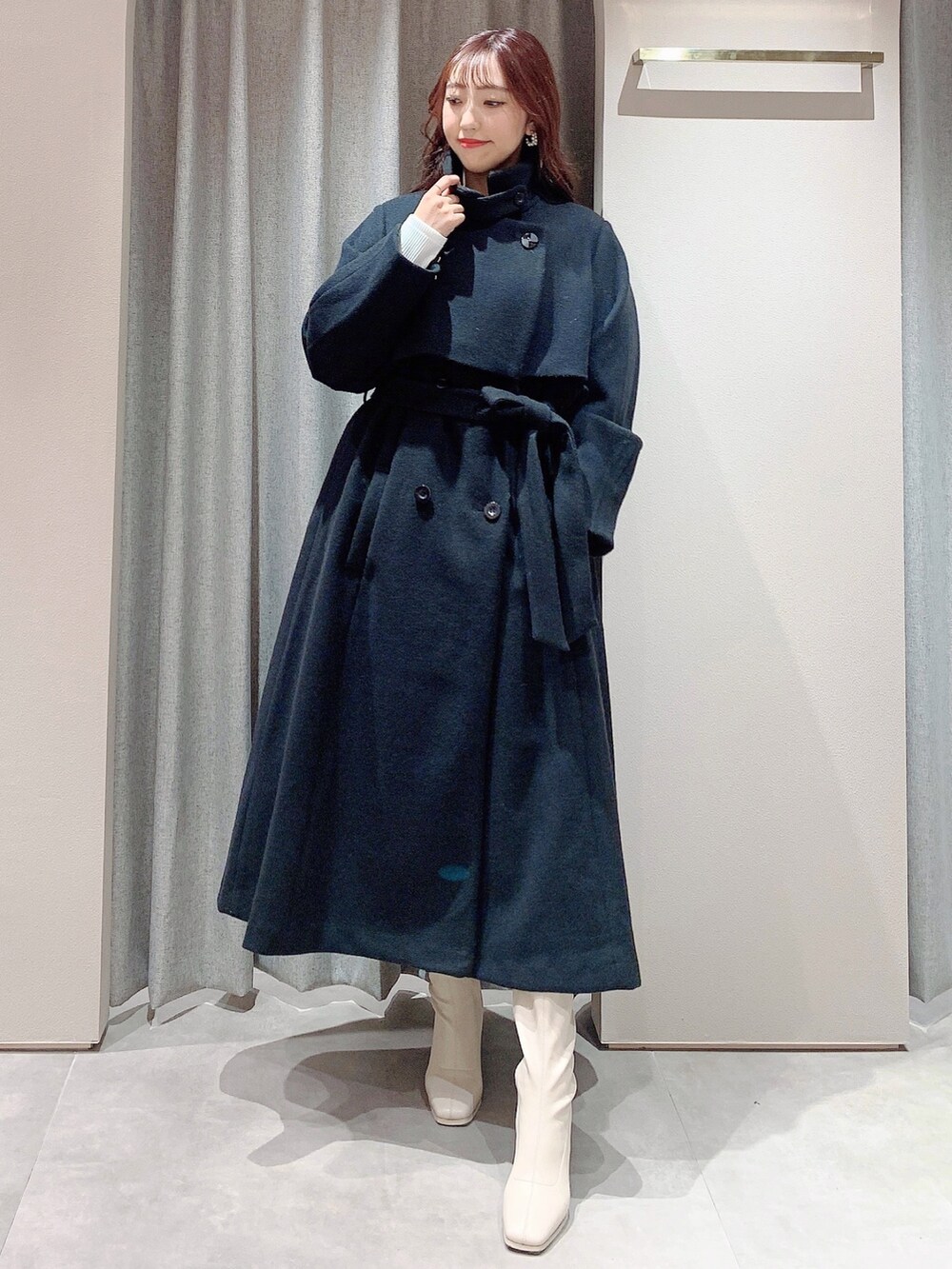 ホワイト系のワンピース、ホワイト系のブーツ、ブラック系のその他アウターを着用したレディースの冬コーディネートの4枚目の写真