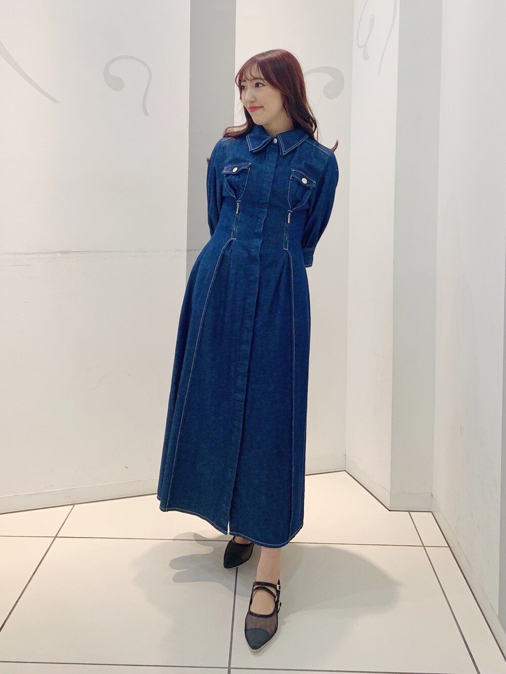 ブルー系のワンピース、ブラック系のパンプスを着用したレディースの冬コーディネートの2枚目の写真