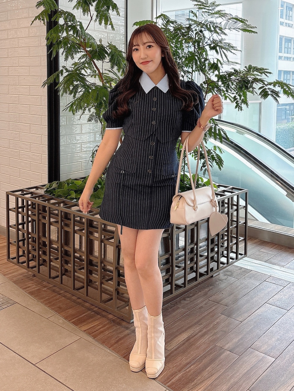 ホワイト系のブーツ、ブルー系のワンピースを着用したレディースの春コーディネートの2枚目の写真