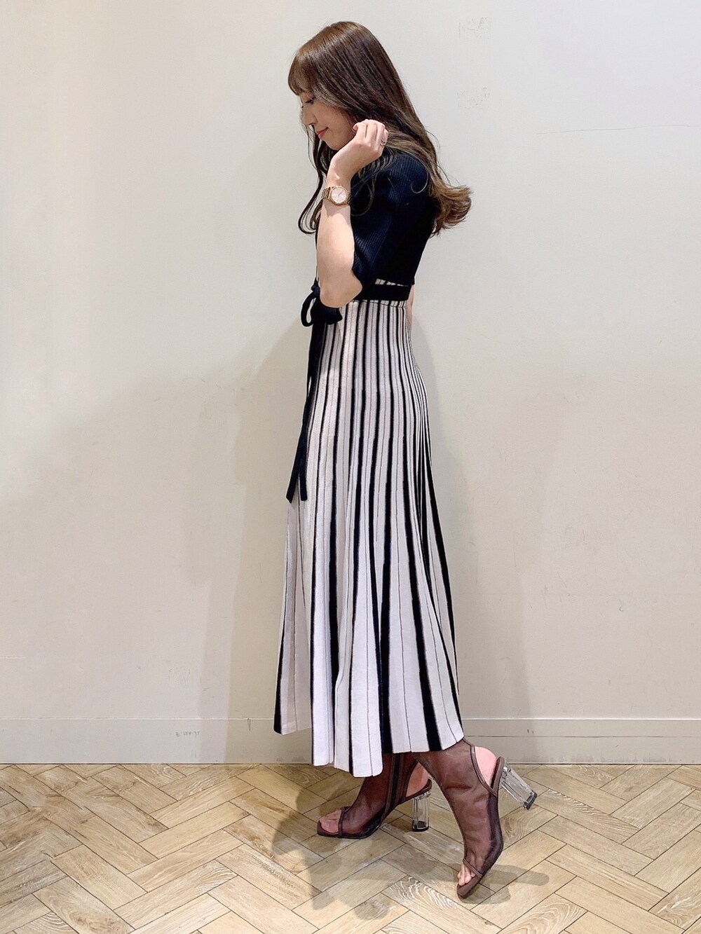 ブラック系のワンピース、ブラウン系のブーツを着用したレディースの春コーディネートの5枚目の写真