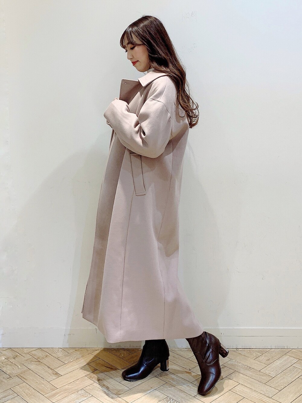 ホワイト系のワンピース、ベージュ系のステンカラーコート、ブラウン系のブーツを着用したレディースの冬コーディネートの8枚目の写真