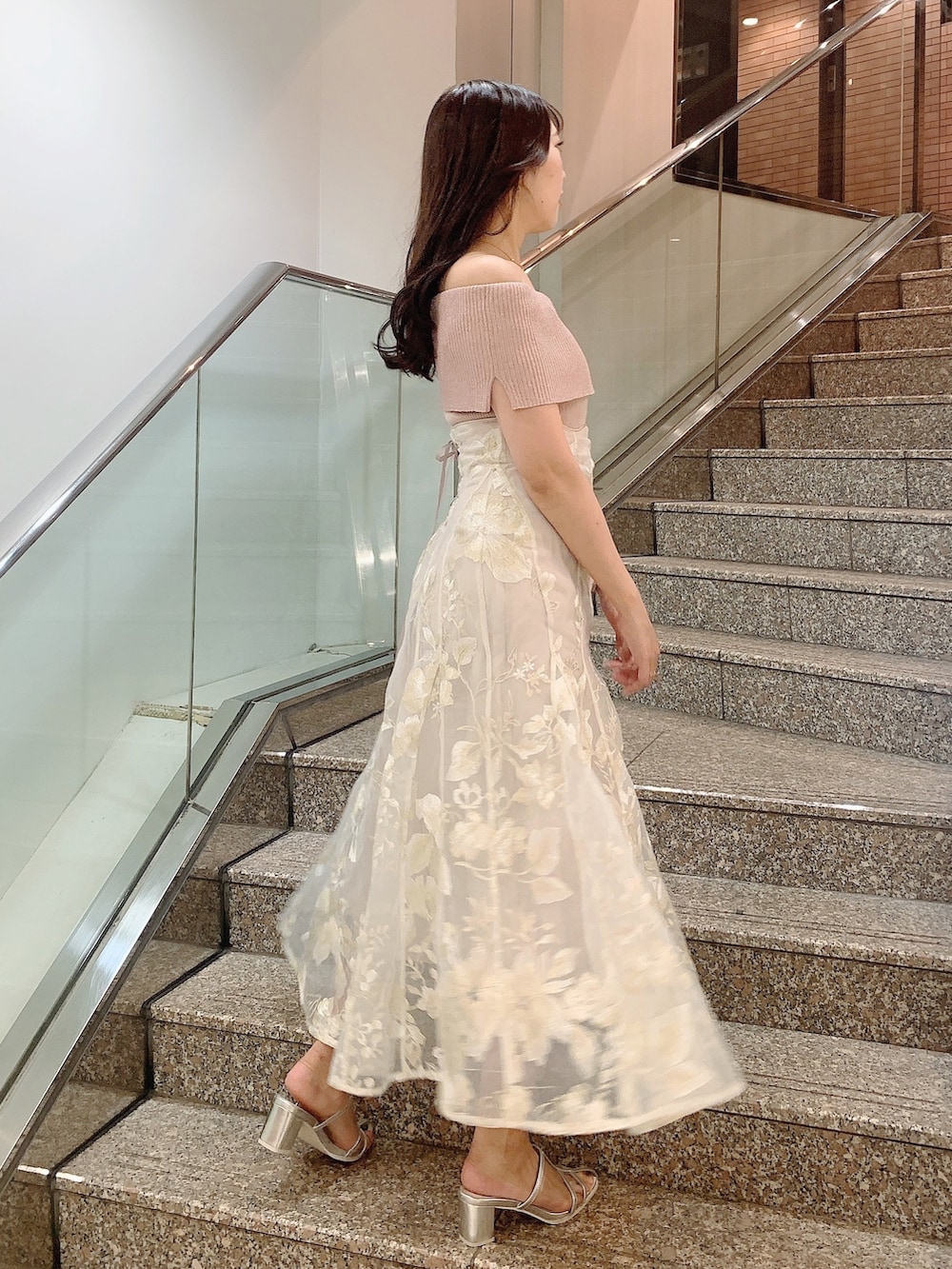 ベージュ系のスカート、ピンク系のニット/セーター、シルバー系のパンプスを着用したレディースの夏コーディネートの5枚目の写真