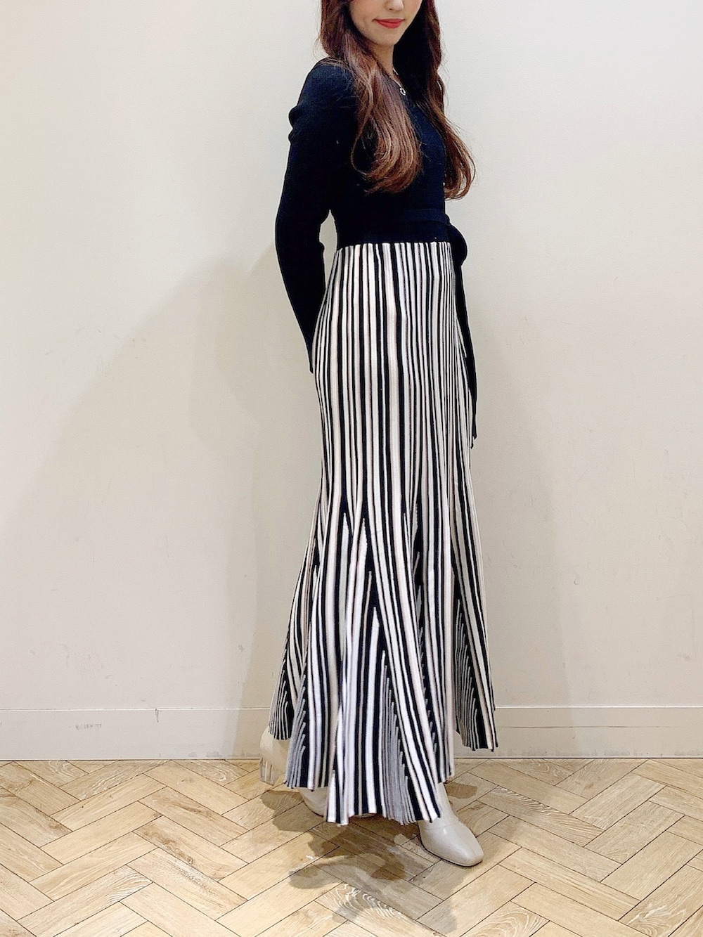 ブラック系のワンピース、ブラック系のダウンジャケット/コート、ホワイト系のブーツを着用したレディースの冬コーディネートの3枚目の写真