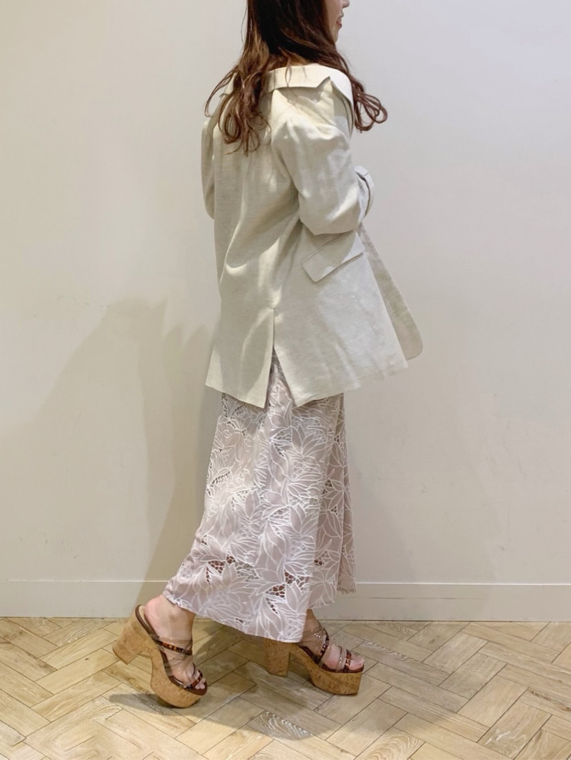 ホワイト系のテーラードジャケット、ベージュ系のワンピース、ベージュ系のサンダルを着用したレディースの春コーディネートの4枚目の写真