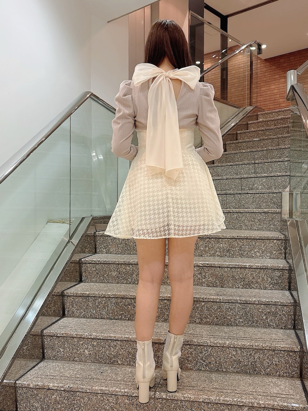 ホワイト系のブーツ、ベージュ系のワンピースを着用したレディースの冬コーディネートの6枚目の写真