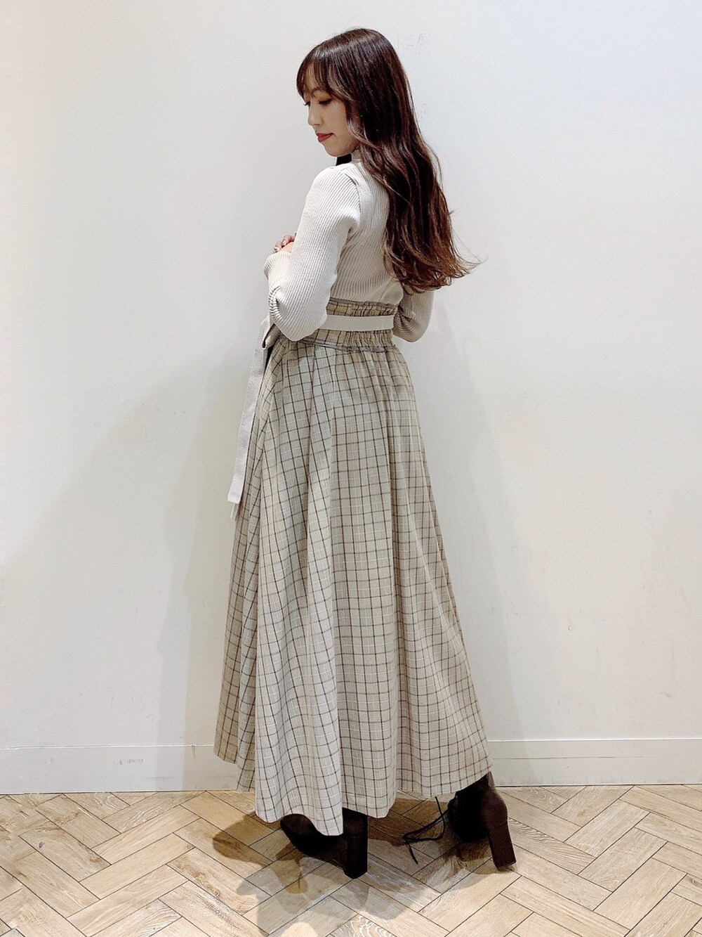 ブラウン系のチェスターコート、ブラウン系のブーツ、ベージュ系のワンピースを着用したレディースの冬コーディネートの5枚目の写真