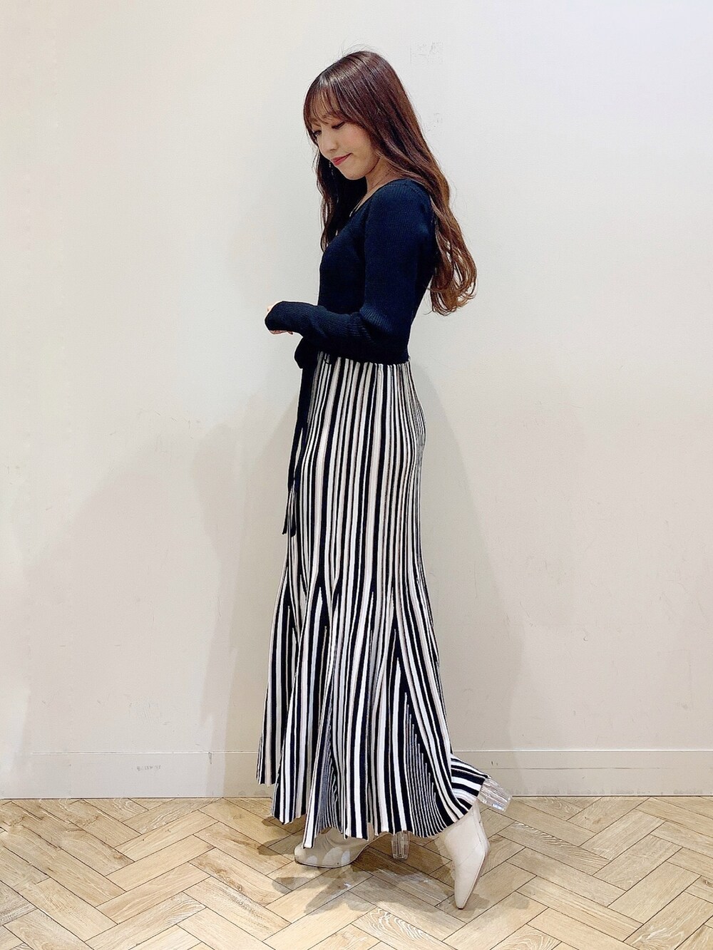 ブラック系のワンピース、ブラック系のダウンジャケット/コート、ホワイト系のブーツを着用したレディースの冬コーディネートの4枚目の写真