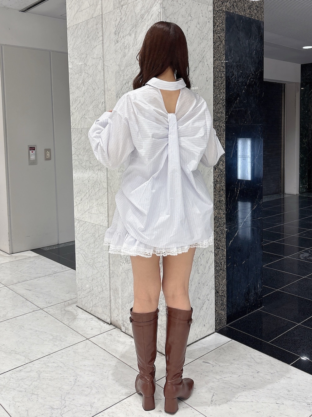 ブラウン系のブーツ、ホワイト系のシャツ/ブラウス、ホワイト系のスカートを着用したレディースの春コーディネートの5枚目の写真