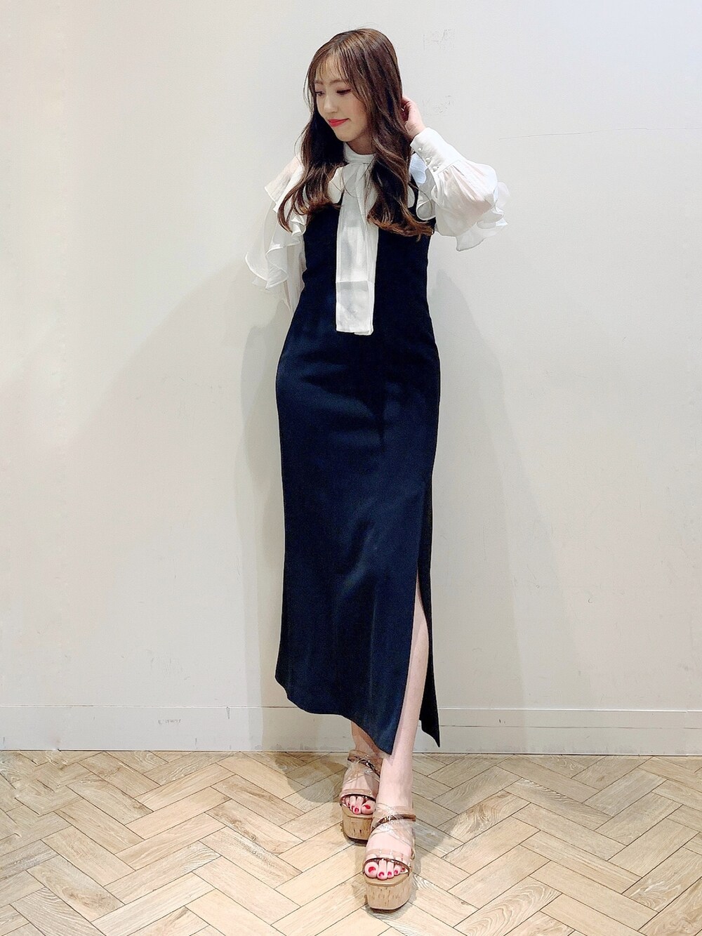 ブラック系のワンピース、ホワイト系のシャツ/ブラウス、ブラウン系のサンダルを着用したレディースの春コーディネートの3枚目の写真