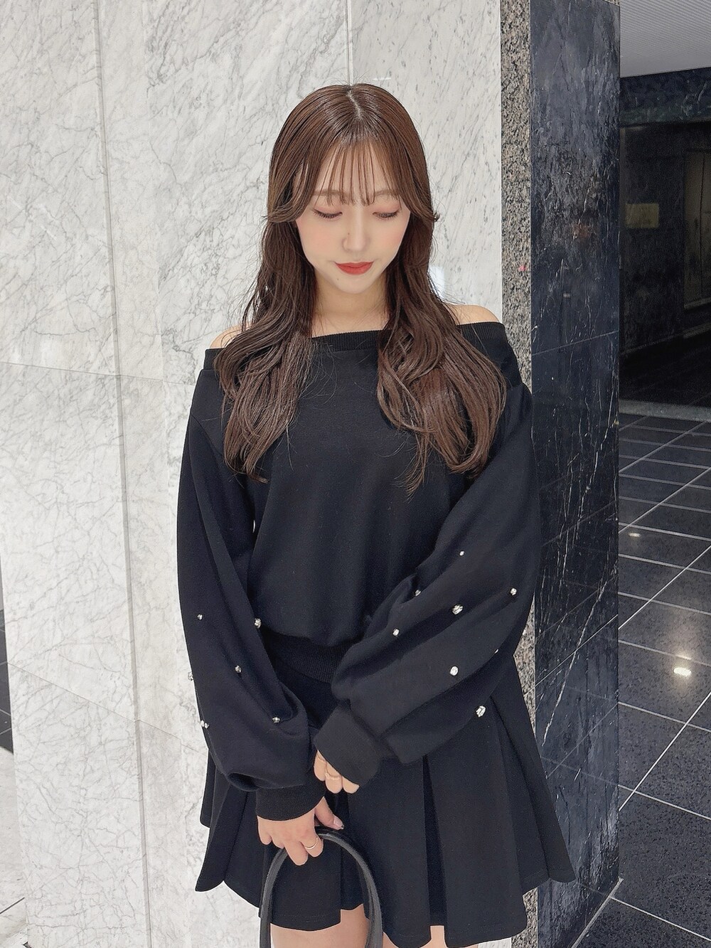 ブラック系のスカート、ブラック系のスウェット、ブラック系のブーツを着用したレディースの秋コーディネートの8枚目の写真