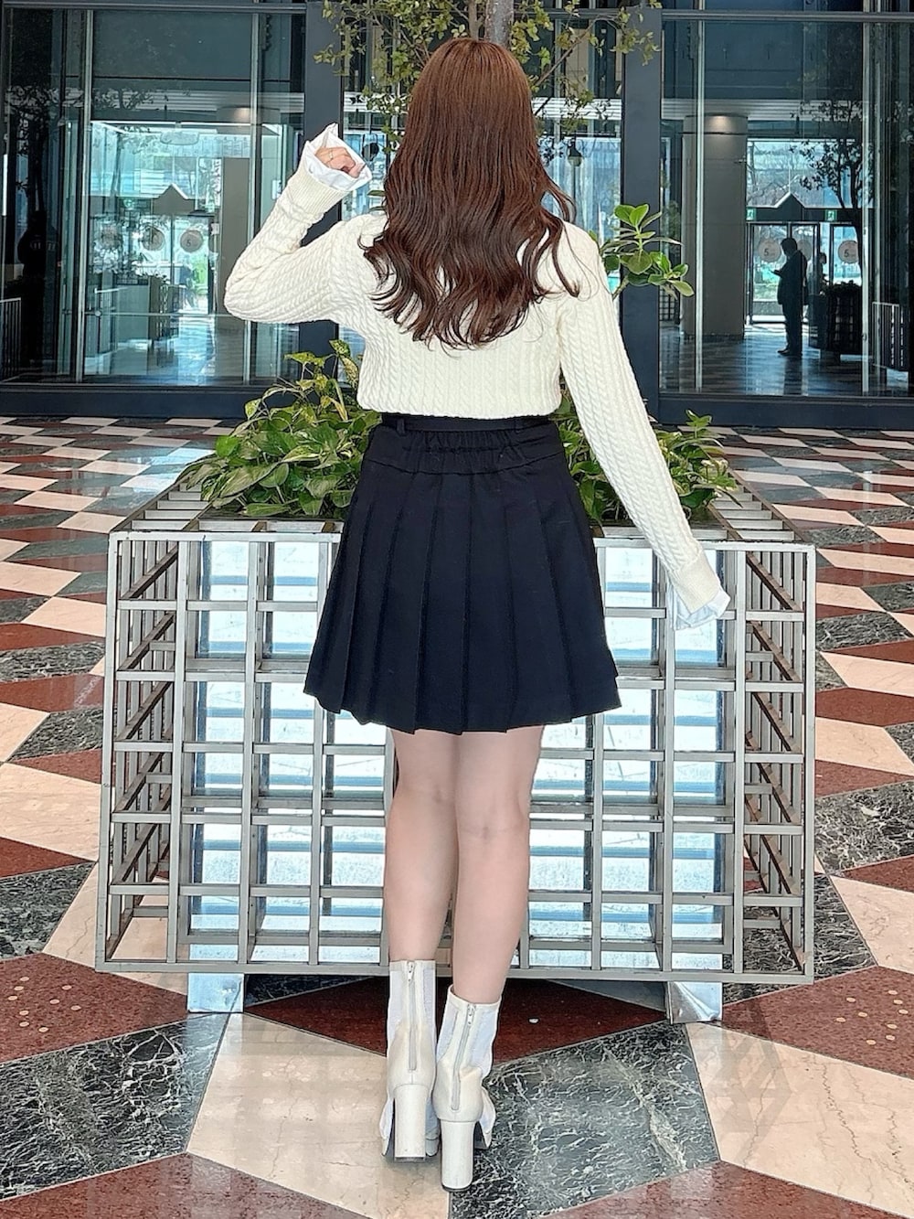 ホワイト系のブーツ、ブラック系のスカート、ホワイト系のニット/セーターを着用したレディースの冬コーディネートの7枚目の写真