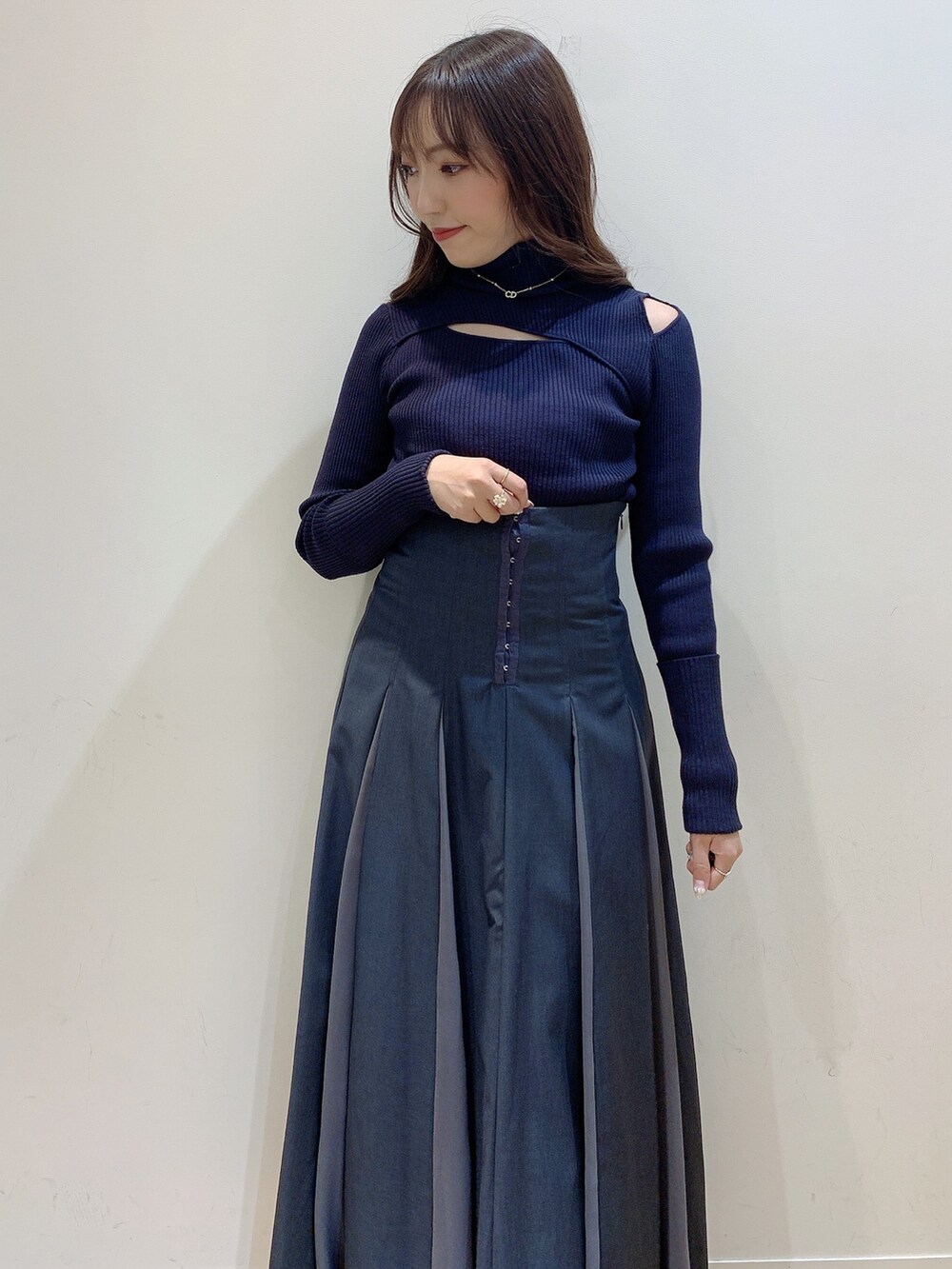 グレー系のニット/セーター、グレー系のスカート、ホワイト系のブーツを着用したレディースの冬コーディネートの10枚目の写真