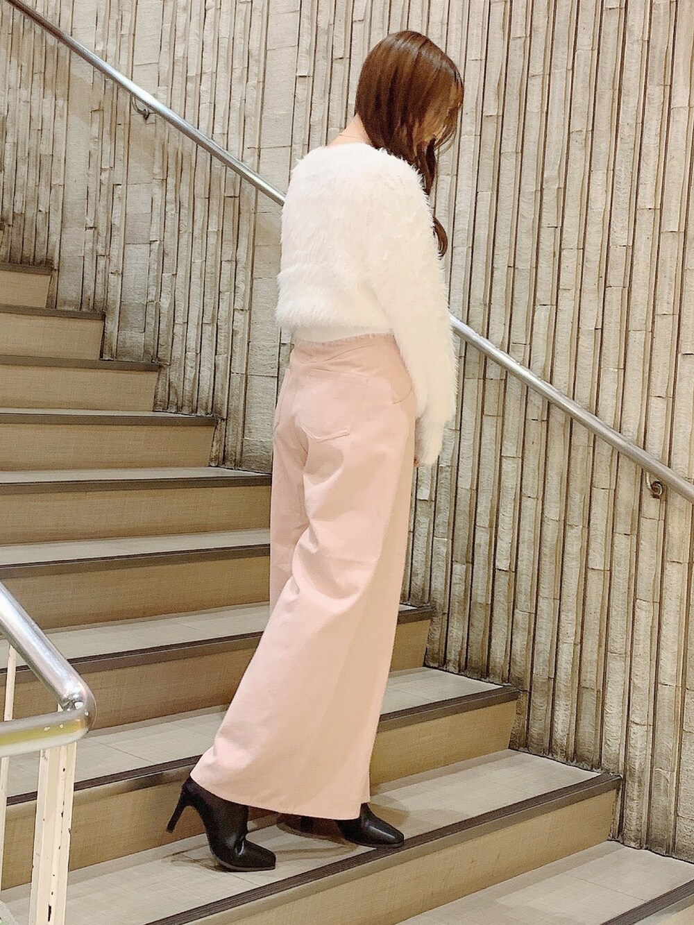 ブラック系のブーツ、ピンク系のデニムパンツ、ホワイト系のカーディガン/ボレロを着用したレディースの秋コーディネートの3枚目の写真