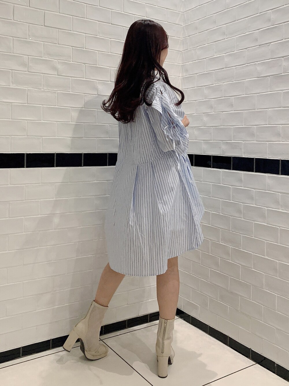 ブルー系のシャツワンピース、ホワイト系のブーツ、ホワイト系のキャミソールを着用したレディースの春コーディネートの3枚目の写真